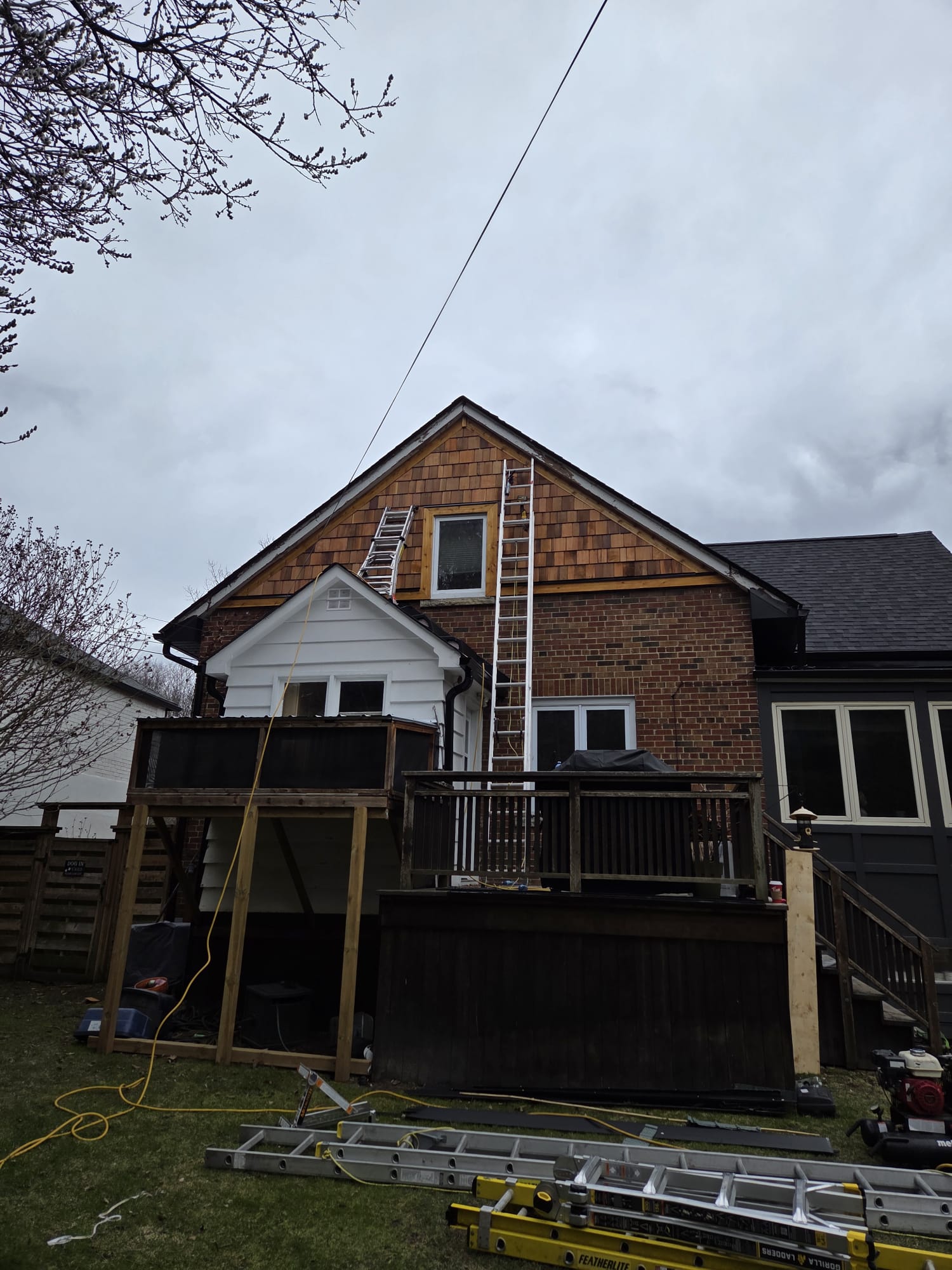 Finished dark asphalt shingle roof on a modern two-storey home with white trim and wraparound porch